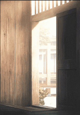 a wooden door is open and the sun is shining through the window