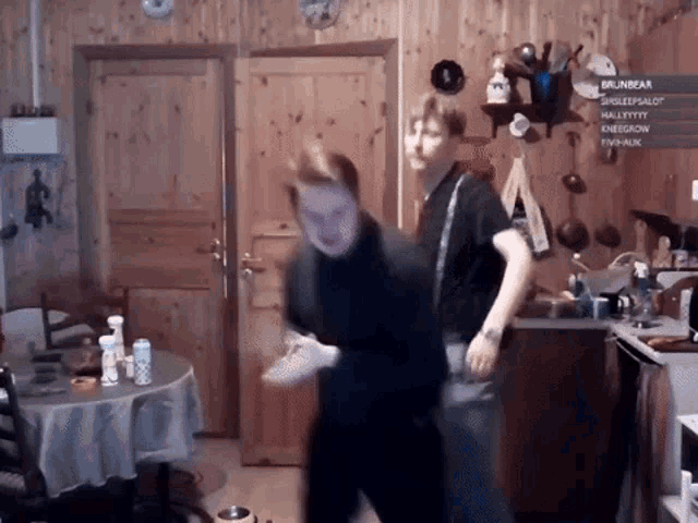 two men are dancing in a kitchen with a sign that says brunbear on it