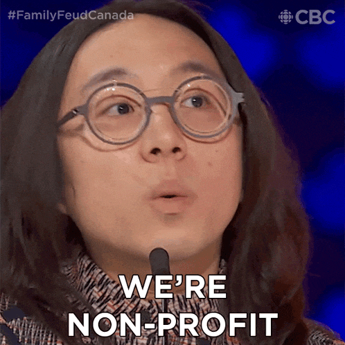 a woman with glasses says we 're non-profit in front of a microphone