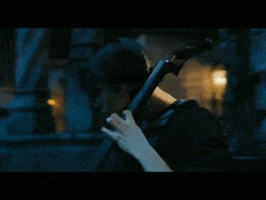 a woman plays a cello in a dark room