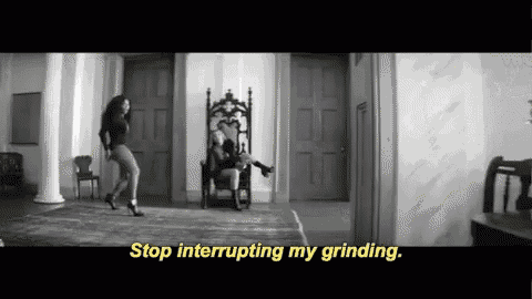 a black and white photo of a woman dancing next to a man in a chair with the words stop interrupting my grinding .