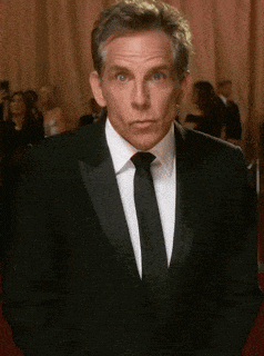 a man in a tuxedo and tie is making a funny face