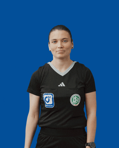 a woman wearing a black adidas shirt with a sticker on her chest that says ' deutsche fussball '