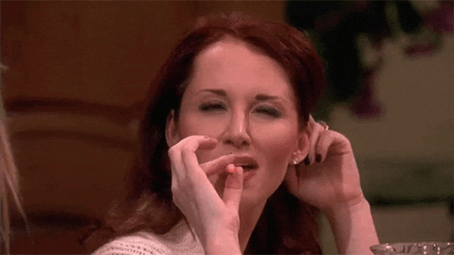 a woman is sitting at a table eating a candy bar .