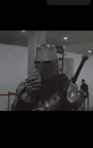 a man in a knight 's armor drinking from a bottle that says ' sprite ' on it