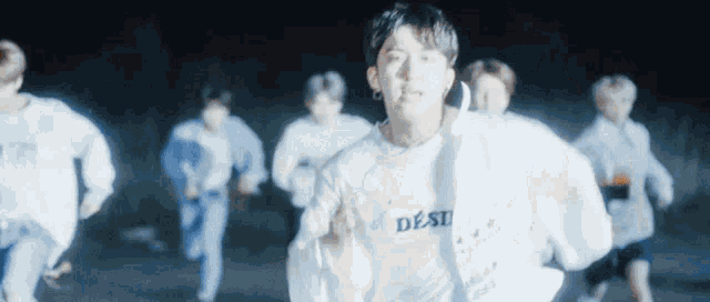 a group of young men are running in a dark room at night .