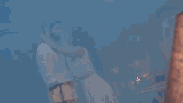 a man and a woman are kissing in front of a fire in a dark room .