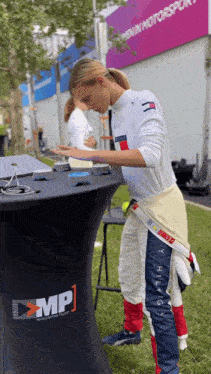 a woman in a tommy hilfiger outfit stands in front of a table