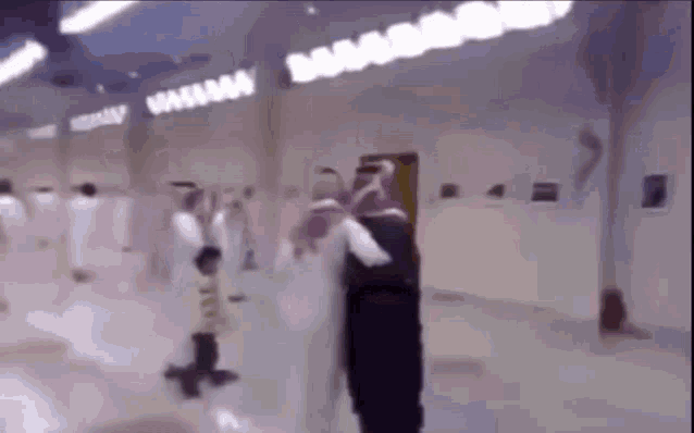 a blurry picture of a group of people in a room with a sign that says ' babama ' on it .