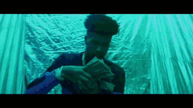 a man is holding a stack of money in his hands