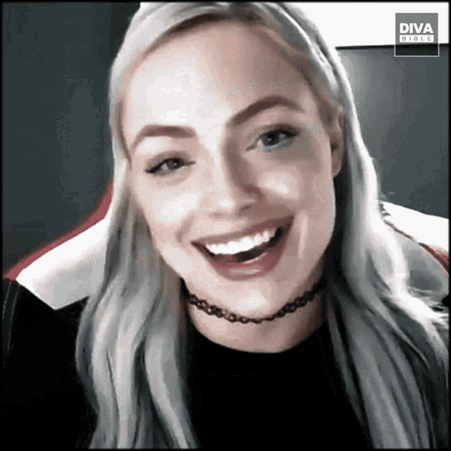 a woman is smiling in front of a diva direct sign