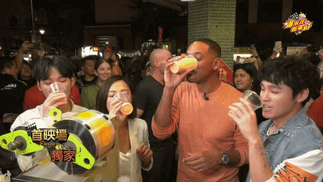 a group of people drinking in front of a machine that says ' new year ' on it