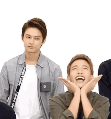 a group of young men are standing next to each other and one of them is laughing .