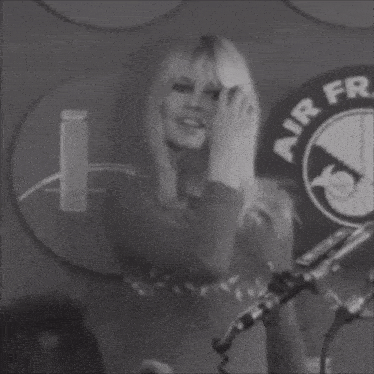 a black and white photo of a woman singing in front of a sign that says air france