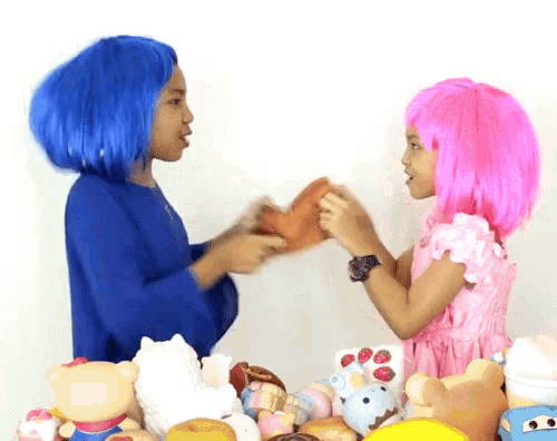 a girl with blue hair and a girl with pink hair playing with stuffed animals