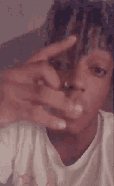 a close up of a person making a peace sign with their hands .