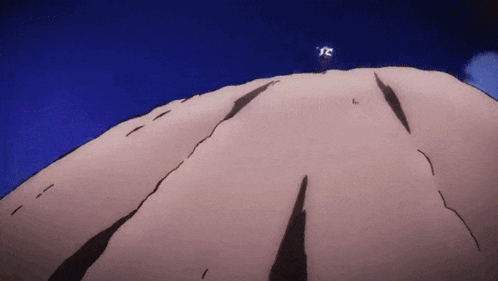 a person is standing on top of a rocky hill .