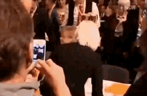 a man is taking a picture of another man with a cell phone