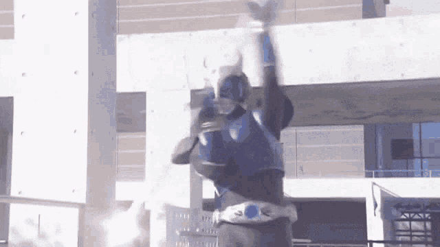 a man in a superhero costume is jumping in the air .