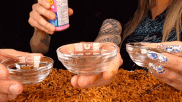 a man and a woman are holding bowls of liquid and a bottle