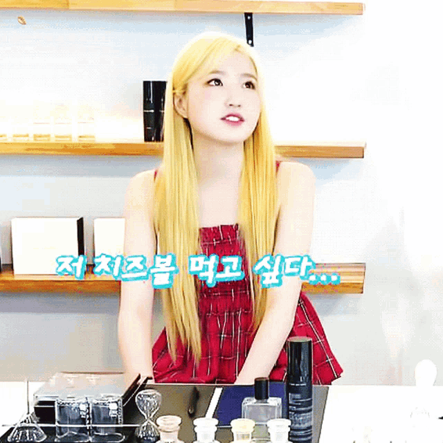 a woman in a plaid dress is sitting at a table with bottles of perfume on it
