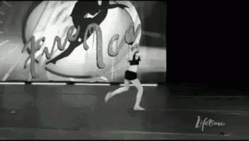 a black and white photo of a woman dancing on a stage in front of a lifetime sign .