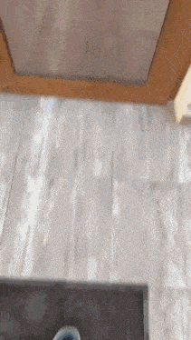 a person is standing on a wooden floor next to a stove .