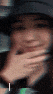 a blurry picture of a person covering their mouth with their hand