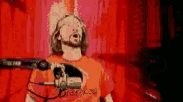 a pixel art of a man singing into a microphone with a shirt that says dreamcast