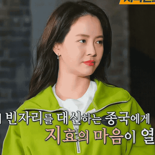 a woman is wearing a green jacket with chinese writing on it