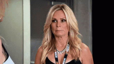 a woman wearing a black tank top and a necklace with a lanyard around her neck .
