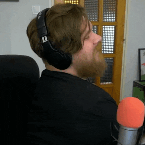 a man with a beard is wearing headphones and looking at the camera