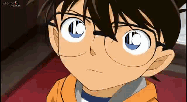 a close up of a boy wearing glasses and an orange hoodie .