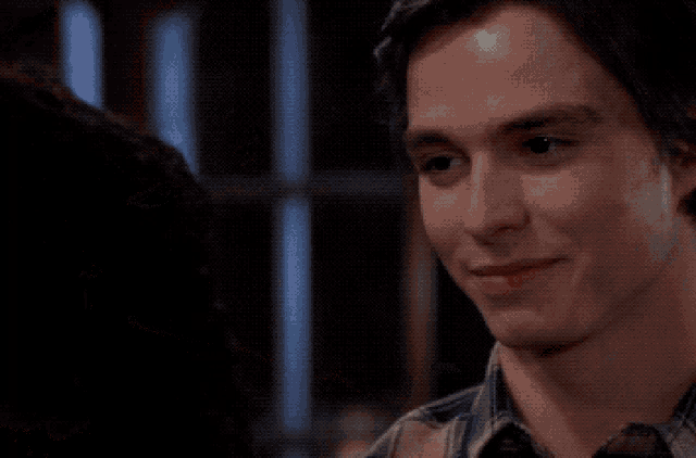 a man in a plaid shirt looks at a woman