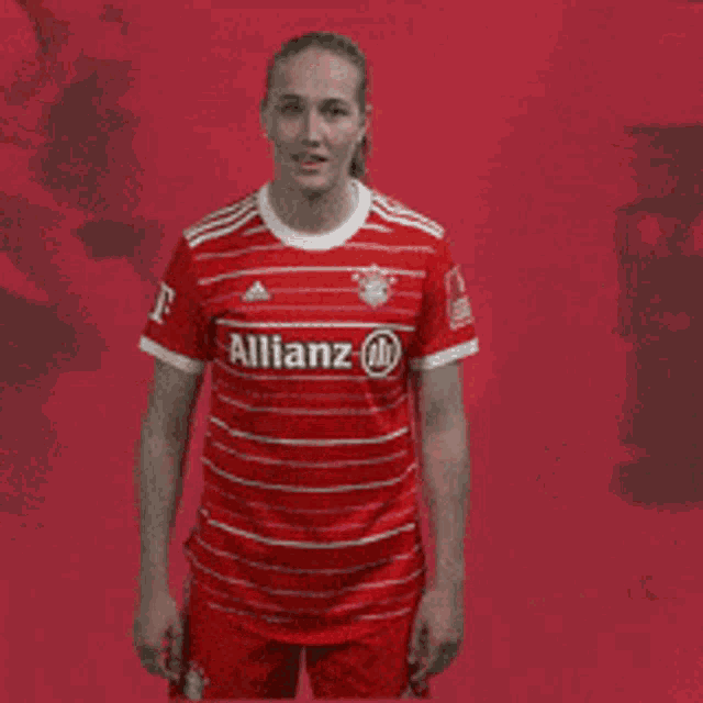 a woman wearing a red shirt with the letter t on the front