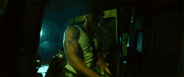 a man in a yellow tank top is holding a rifle in front of a sign that says ' a ' on it
