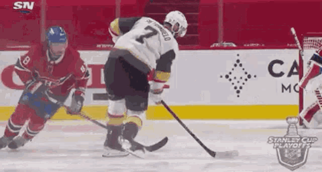 two hockey players are playing a game of hockey on the ice . one of the players is wearing the number 21 jersey .