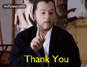 a man with a beard is giving a thumbs up and saying `` thank you '' .