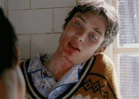 a man with blood on his face is wearing a sweater that says " tokyo "