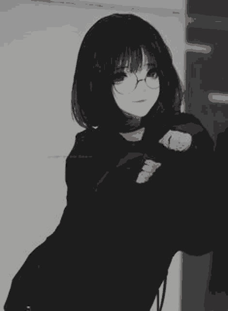 a black and white photo of a girl wearing glasses and a black shirt .