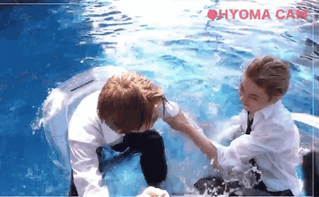 two people in a swimming pool with the word hyoma can be seen