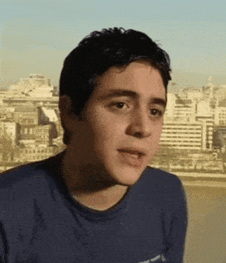 a young man wearing a blue shirt that says ' abercrombie & fitch ' on the front