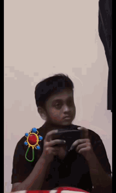 a boy playing a video game with a baby rattle on his arm