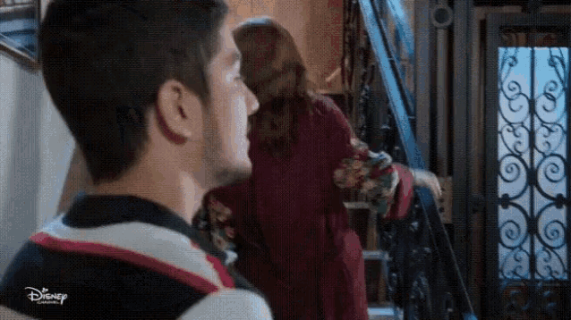 a man and woman are standing next to each other on a set of stairs .