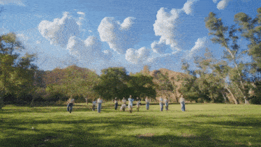 a group of people standing in a circle in a grassy field
