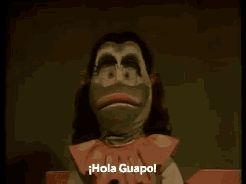 a cartoon character is waving and saying hola guapo in spanish .
