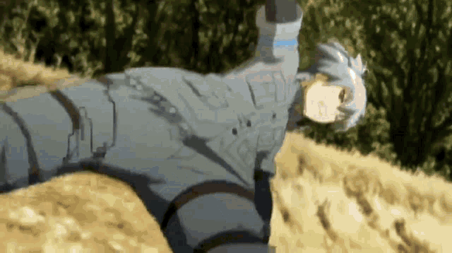 a man in a gray suit is laying on his back on a dirt field .