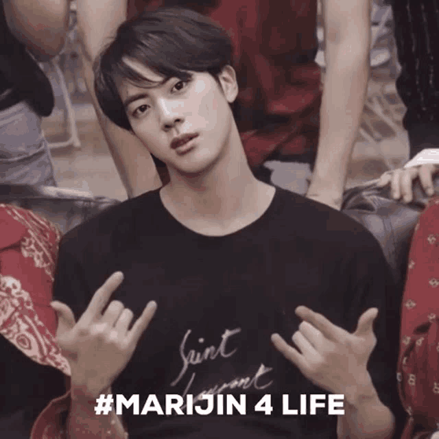 a young man wearing a saint laurent t-shirt is making a peace sign