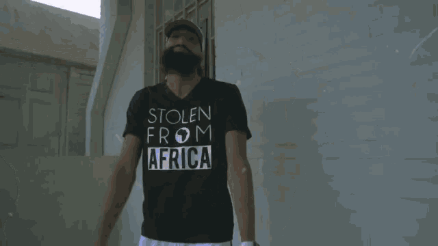 a man with a beard wearing a stolen from africa shirt
