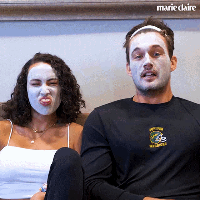 a man wearing a jupiter warriors shirt sits next to a woman with a face mask